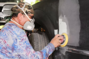Auto body repair technician sanding a vehicle before paint refinishing at Toyo Tec in Cypress, TX